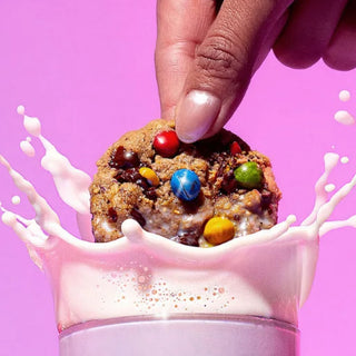 Sweet Loren's Monster cookie being dipped into a splash of milk