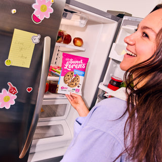 Woman smiling as she takes Sweet Loren's Chocolate Chunk Cookie Dough from the refrigerator